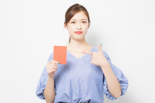 レッドカードを手に持つ若い女性